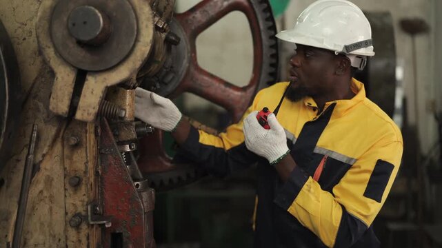 Professional industrial engineer communicating with walkie talkie during factory inspection