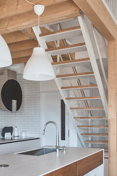 Warm wood kitchen stair interior with pendant lights in custom modern home