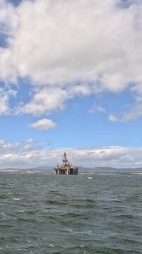 Distant Offshore Oil Rig on Choppy Sea Under Cloudy Sky