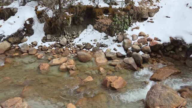 Clear Mountain Stream Flowing Over Rocks in a Snow-Covered Winter Landscape, Bipenggou (Bipeng Valley), Sichuan Province, China.
