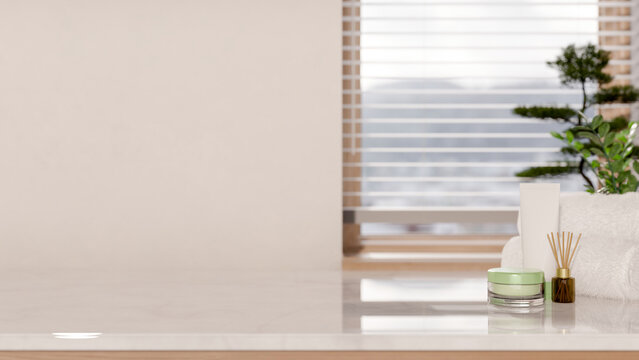 White towel with diffuser and cream jar on marble counter table across window blinds in modern room