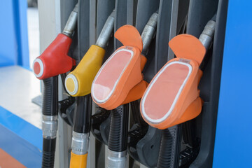 Color coded fuel nozzles rest in gas station dispenser, showing everyday energy service, transport choice and refueling routine. © SOLDATOOFF