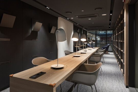 Cozy study library with long communal desk and warm task lighting