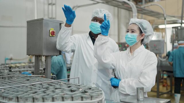Quality Control Inspection: A duo of dedicated inspectors, clad in protective gear, meticulously surveys the production line, ensuring the quality and precision of the manufacturing process.