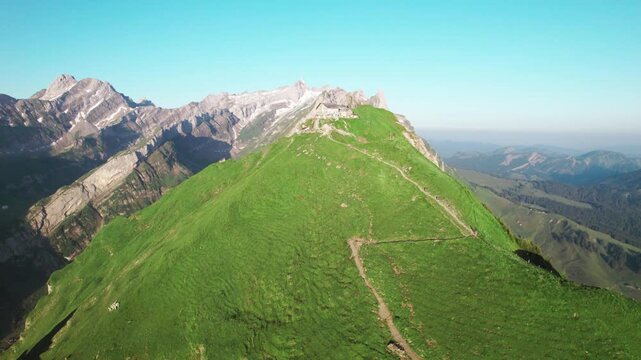 Aerial 4k drone view of Schaeffler Hut on a green alpine ridge, Swiss Alps mountain lodge, dramatic peaks, hiking destination, summer landscape, alpine travel scenery in Switzerland