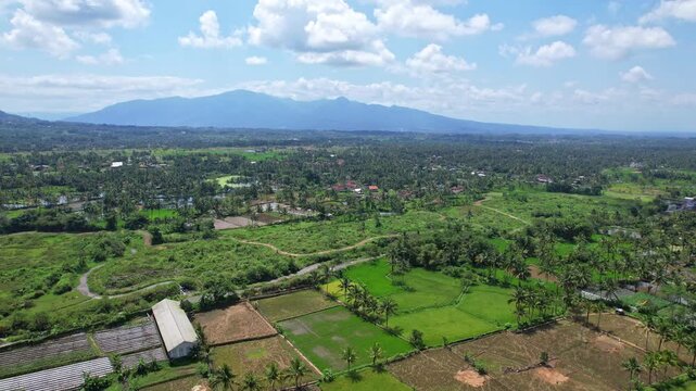 Aerial drone footage of a main agriculture area, with road leading to Tasik,nearby Galunggung volcano mountain, in the morning, villages around and hill, in Tasikmalaya regency, Java island, Indonesia