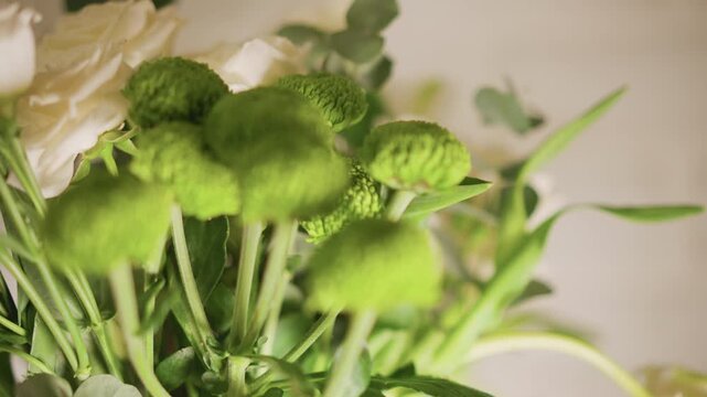 Lively kitchen bouquet of green pompon blooms and white blossoms on counter, textured foliage with shallow focus, fresh centerpiece styling, morning light and vibrant home mood, cook centerpiece