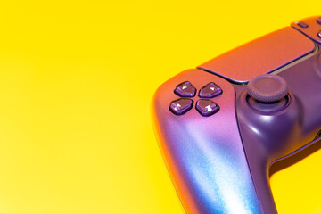 A gamepad for consoles on a yellow background, gaming addiction, gaming ban for teenagers, gaming controls for parents, for banners and advertising. High quality © Karen Vardanian