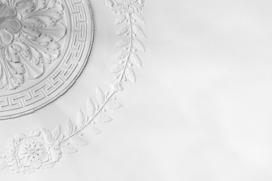 Classic white plaster ceiling medallion with decorative floral molding, showcasing classical relief detail and elegant texture ideal for architecture, interior design, restoration and luxury decor