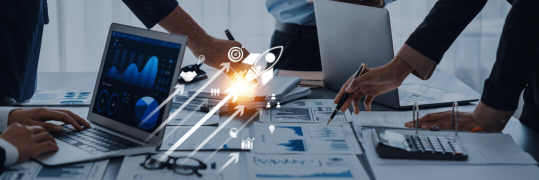 A dynamic business meeting showcasing professionals collaborating with laptops and data charts to analyze strategies for growth and innovation in a modern workspace. Trope