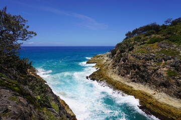 Fototapeta premium Powerful ocean waves crashing between rocky cliffs at North Stradbroke Island Australia