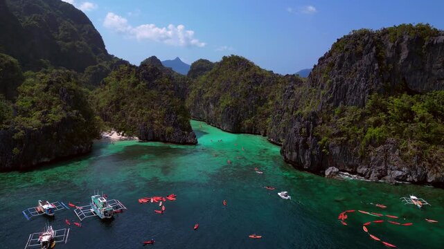 Big Lagoon in El Nido limestone karsts with kayakers. Lovely aerial view drone