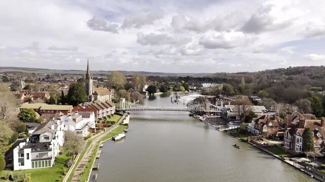 Aerial drone footage flying over Marlow High Street in Buckinghamshire, England, following the road in a northerly direction. Scenic view of a traditional British town with shops and buildings. 