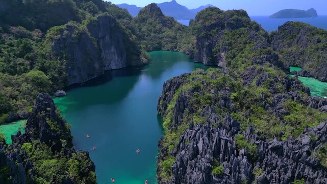 Big Lagoon in El Nido limestone karsts with kayakers. Stunning aerial view drone