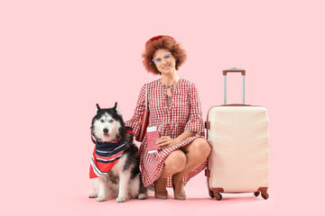 Female tourist with Husky dog and suitcase on pink background © Pixel-Shot