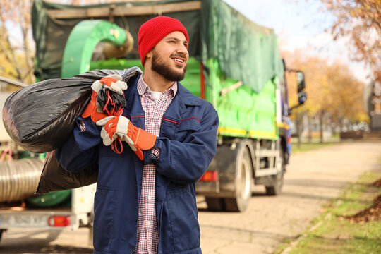 Male scavenger with garbage bags on street