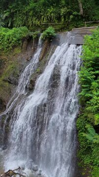 Scenic view of tropical waterfall cascading down rocky cliffs into hidden pool