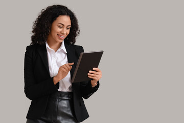 Fototapeta premium Female African-American job applicant with tablet computer on light background