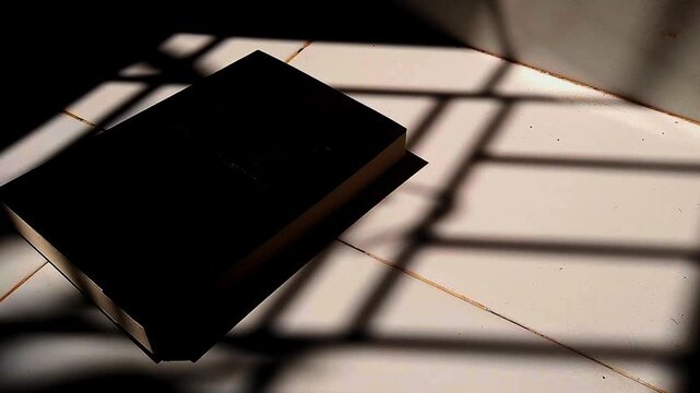 Black Book with Dramatic Shadows on Floor, Minimalist Light and Shadow Concept