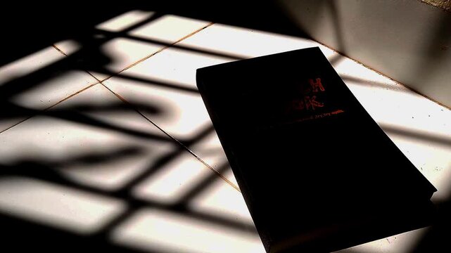 Black Book with Dramatic Shadows on Floor, Minimalist Light and Shadow Concept