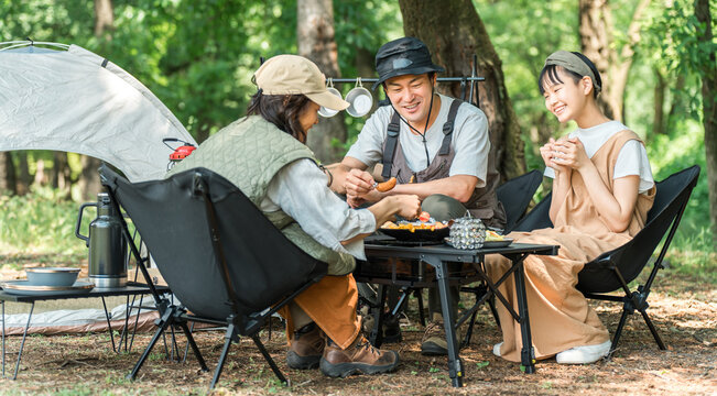 A close-knit family enjoying day camping, camping, and barbecues at a park/campsite.