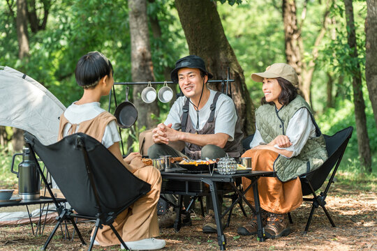 A close-knit family enjoying day camping, camping, and barbecues at a park/campsite.