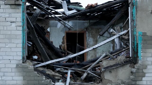 Ruined house with a collapsed roof and debris after a disaster or military conflict