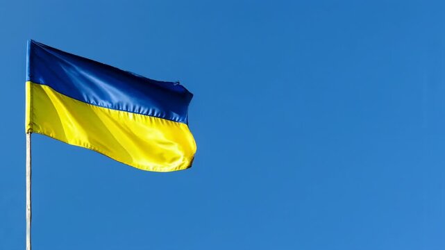 The national flag of ukraine waving in the wind against a clear blue sky on a sunny day