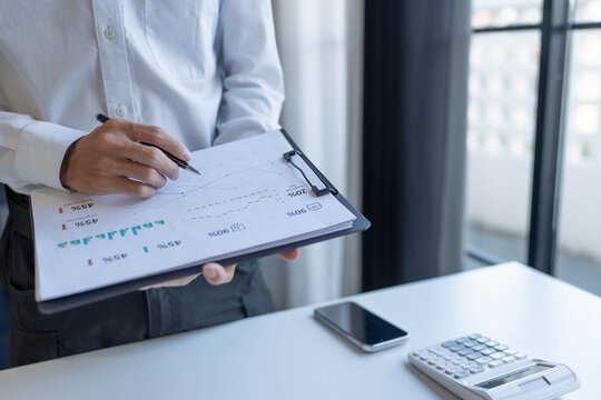 Businessman standing chekking documents with pen