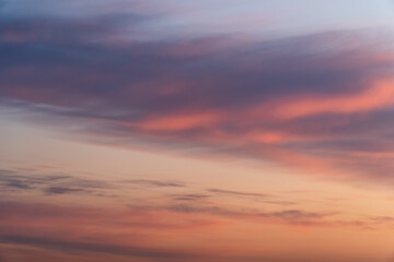 Fototapeta premium Majestic real sunrise sundown sky background with gentle colorful clouds. Panorama of cloudscape at sunset with vivid and dreamy colors on sky. A vibrant sunset sky painted in hues of orange pink. 