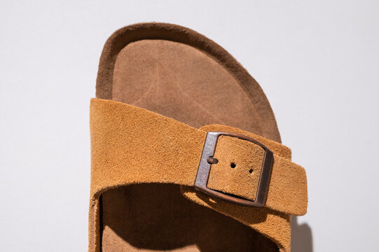 Close up of brown leather sandals. Summer footwear made of genuine leather, soft nubuck, cork soles. Details of fashionable birkenstock sandals, unisex beach and city shoes