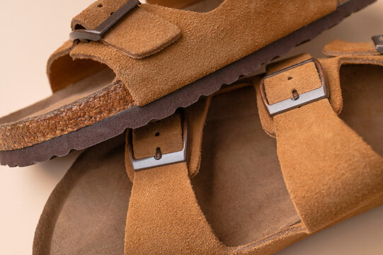 Close up of brown leather sandals. Summer footwear made of genuine leather, soft nubuck, cork soles. Details of fashionable birkenstock sandals, unisex beach and city shoes
