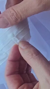 Making a buttonhole with careful hands and clear thread in a bright room during the daytime