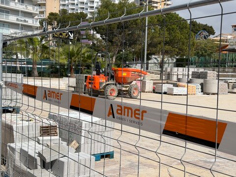 Palmanova, spain, march 26, 2026 construction site showing materials, dump truck, and security fence with amer obres i serveis branding