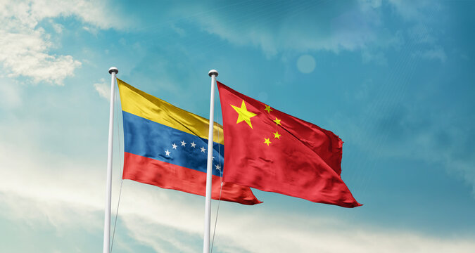 Venezuela and China friendship flags are waving in the sky. Double country Flag waving with mast. Venezuela china national flag for agreement.