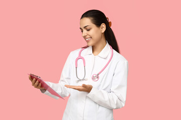 Portrait of female doctor with clipboard on pink background