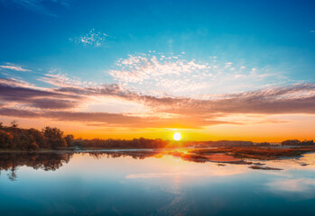 Obraz premium Spectacular bright sunset sky reflected on a calm river