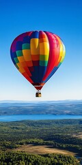 Obraz premium Colorful Hot Air Balloon Ascending Above a Stunning Panoramic Vista of Forest and Lake Below
