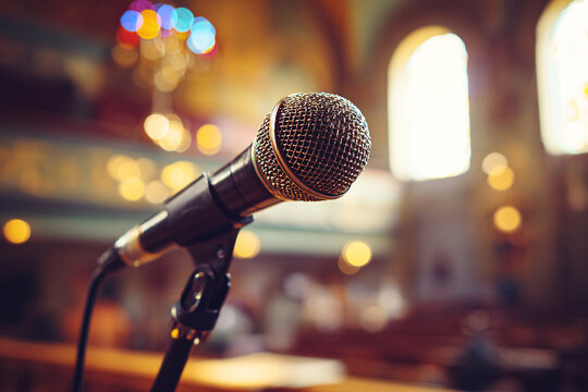 Microphone on Stage with Warm Bokeh Lights in Concer Hall Background