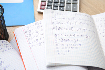 Obraz premium Open copybooks with math formulas on wooden table, closeup