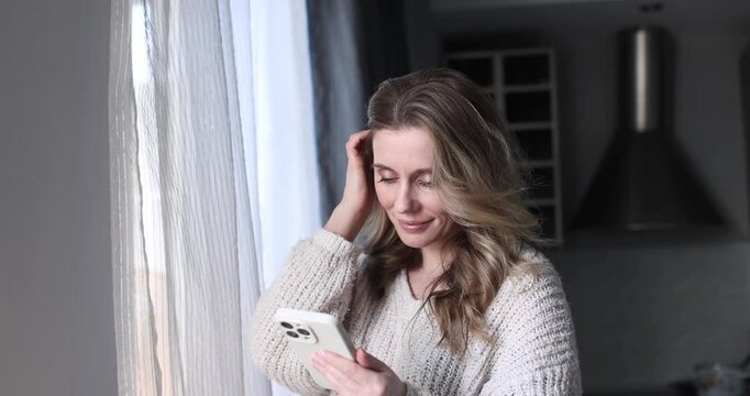 Woman indoors touching forehead with hand, feeling stressed or tired. Woman, stressed, tired, hand, forehead, indoors