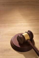 Obraz premium Judge's gavel on sound block on light wooden background in soft sunlight. Represents courtroom authority and legal decisions.