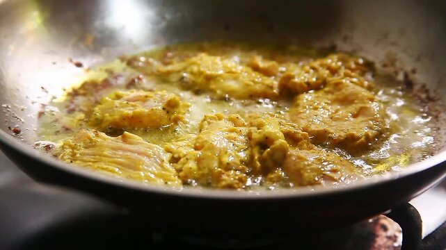 Season chicken breast fillet being cooked on a frying pan