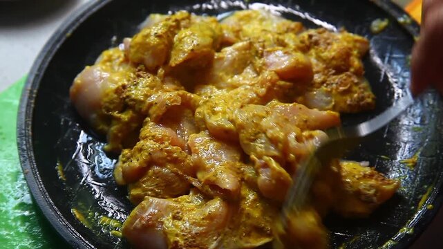 Raw chicken breast being seasoned and prepared for cooking.