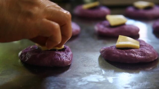 Filipino bread called Ube cheese pandesal being prepared for baking.