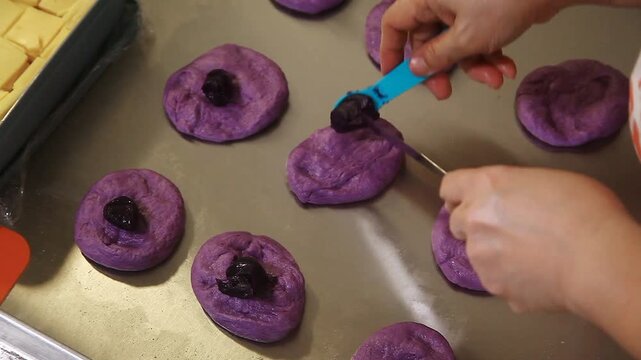 Filipino bread called Ube cheese pandesal being prepared for baking.
