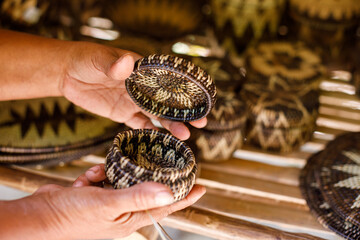 Village market stall displaying handmade bamboo crafts and woven baskets outdoors.