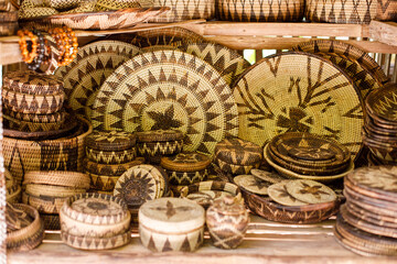 Village market stall displaying handmade bamboo crafts and woven baskets outdoors.