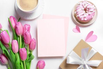 Empty blank greeting card, pink tulips, coffee and pink donut