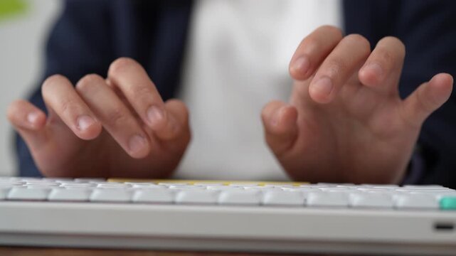 Closeup of a businesswoman's hands typing on a white computer keyboard in the office, illustrating concepts of data entry, programming, writing, and corporate communication in modern business